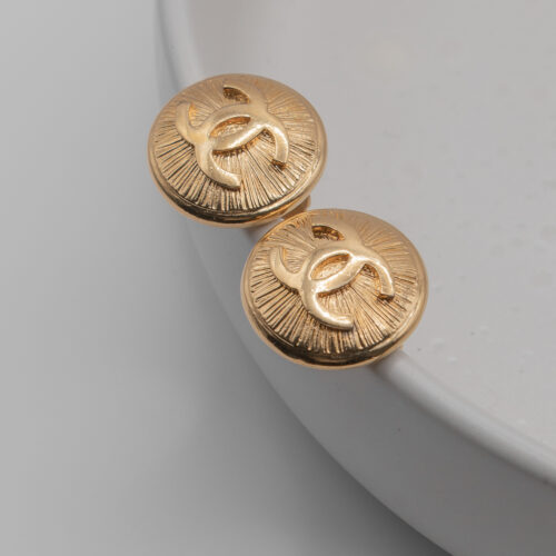 Klipsy Coco Chanel - pozłacane tarcze z fakturą i rzeźbionym wypukłym logo CC, lata 80./90.