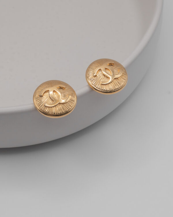 Klipsy Coco Chanel - pozłacane tarcze z fakturą i rzeźbionym wypukłym logo CC, lata 80./90.