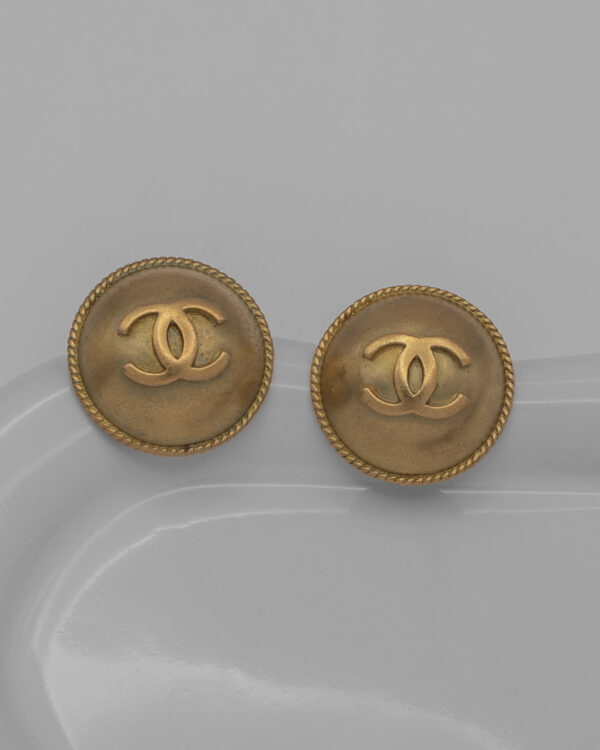 Klipsy Coco Chanel - wypukłe pozłacane tarcze z plecioną obwódką i logo CC, lata 80./90.