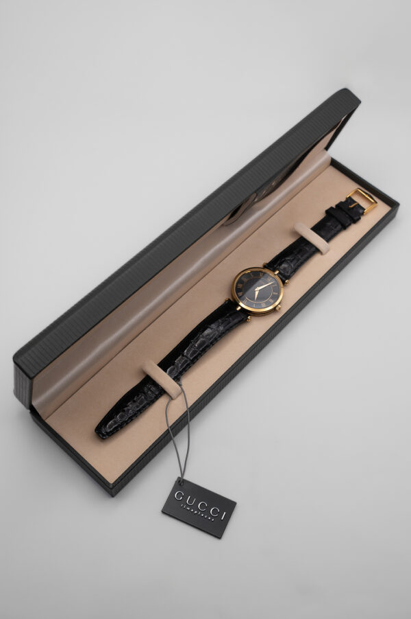 Zegarek Gucci 3000 Series - elegancka złota koperta z czarną tarczą na skórzanym pasku, lata 80./90.