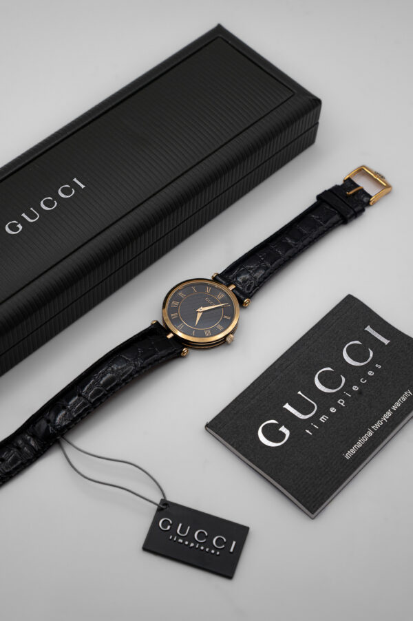 Zegarek Gucci 3000 Series - elegancka złota koperta z czarną tarczą na skórzanym pasku, lata 80./90.